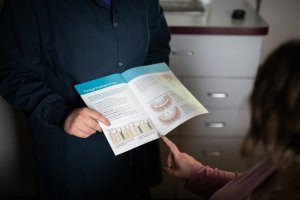 Staff member going over dental implant information with a patient