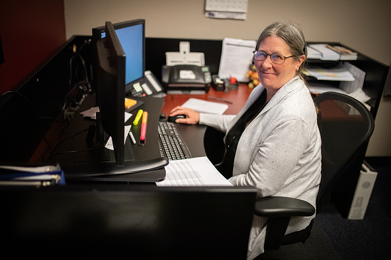 Staff member sitting at a desk with a computer